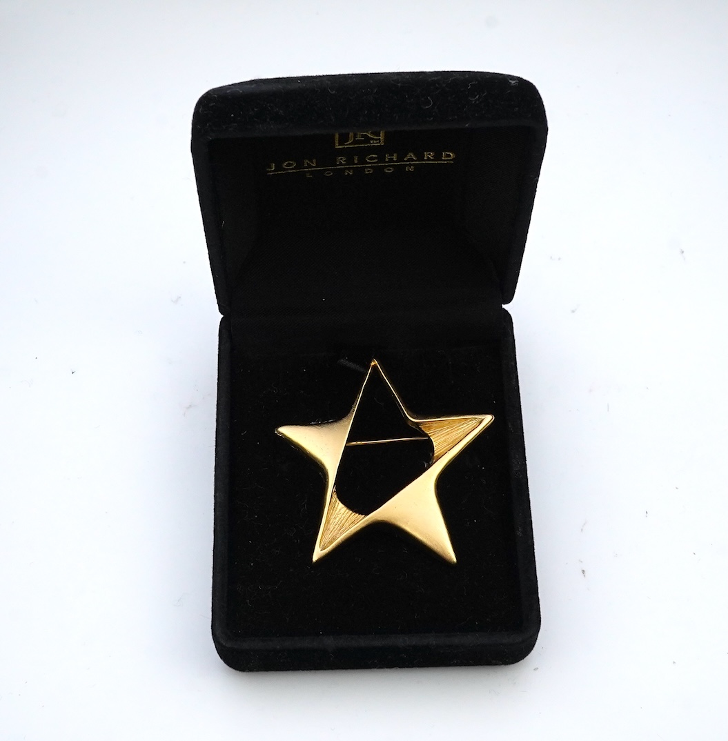 A tarnished gold star brooch in box